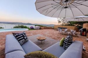 a living room with a couch and an umbrella at Enso Botanico Boutique Wellness Villa, with an outside wood-fire Hot Tub in Kosmos in Hartbeespoort