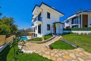 una casa bianca con cortile e piscina di Arıcı evi delux luxury villa with indoor and outdoor pool a Fethiye