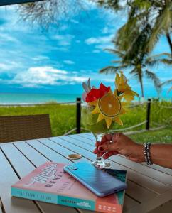 a woman holding a vase with flowers on a table at Baía Branca Beach Resort in Tamandaré