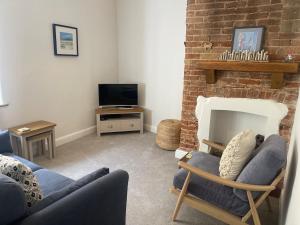 a living room with a couch and a fireplace at Beachway, Cromer in Cromer
