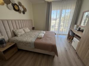 een slaapkamer met een bed en een groot raam bij Villa Lima in Ustka