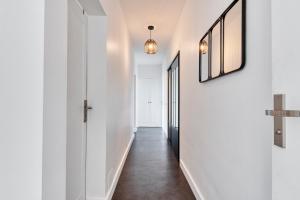 a hallway with white walls and a mirror on the wall at Le Super 8 - Free Parking, Fast WiFi, Calm - Top Angers, Families & Groupes in Angers +15 photos