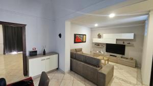 een woonkamer met een bank en een televisie bij Saint Cristofer house in Catania