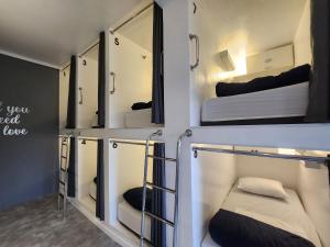 three bunk beds in a room with mirrors at Vila Rock Hostel - próximo Allianz Parque, Vila Madalena, Av Paulista, Hospital das Clínicas INCOR FMUSP in São Paulo