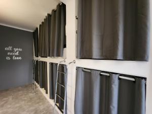 a bathroom with gray shower curtains and a wall at Vila Rock Hostel - próximo Allianz Parque, Vila Madalena, Av Paulista, Hospital das Clínicas INCOR FMUSP in São Paulo
