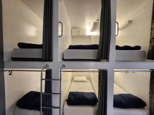 a room with three bunk beds and a mirror at Vila Rock Hostel - próximo Allianz Parque, Vila Madalena, Av Paulista, Hospital das Clínicas INCOR FMUSP in São Paulo