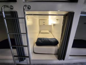 a small bed in a bunk room with a ladder at Vila Rock Hostel - próximo Allianz Parque, Vila Madalena, Av Paulista, Hospital das Clínicas INCOR FMUSP in São Paulo