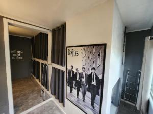 a hallway with a picture of the beatles on the wall at Vila Rock Hostel - próximo Allianz Parque, Vila Madalena, Av Paulista, Hospital das Clínicas INCOR FMUSP in São Paulo