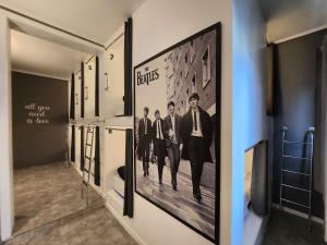 a hallway with a framed picture of three men in suits at Vila Rock Hostel - próximo Allianz Parque, Vila Madalena, Av Paulista, Hospital das Clínicas INCOR FMUSP in São Paulo