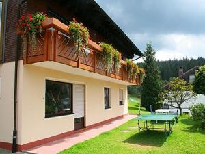 a house with a table and a balcony with flowers at Haus Schwarzwald in Furtwangen