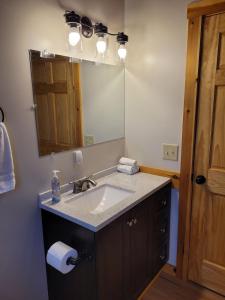 a bathroom with a sink and a mirror at Barn Cottage close to Smugglers Notch in Cambridge +33 photos
