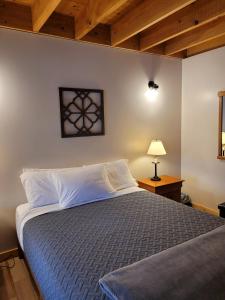 a bedroom with a bed and a table with a lamp at Barn Cottage close to Smugglers Notch in Cambridge