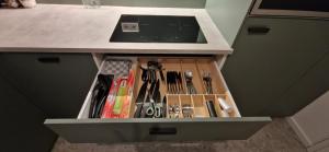 a drawer in a cabinet filled with utensils at Bella - Zwischen Arena & Zoo stilvolle Unterkunft mitten in Gelsenkirchen-Schalke in Gelsenkirchen