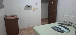 a small room with a bed and a counter and a door at Pousada Jardim do Éden in Parnamirim