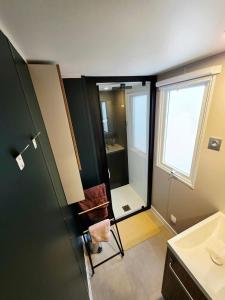 a bathroom with a shower and a chair in it at Mobilhome 6-8 pers - 3 ch - 1 sdb - Parc Aquatique in Vias