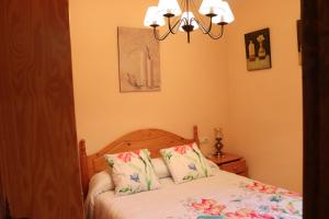 una camera da letto con un letto e un lampadario di La Torreta a Gerbe