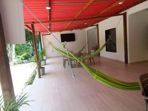 a hammock in a room with a table and a tv at La Casa del Marino in Los Naranjos