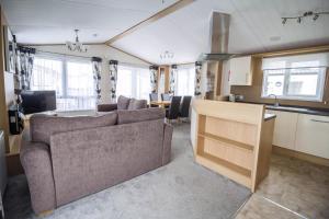 a living room and kitchen with a couch and a table at Beautiful Lodge At Manor Park Nearby Hunstanton Beach Ref 23021C in Hunstanton