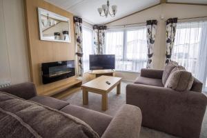 a living room with two couches and a tv at Beautiful Lodge At Manor Park Nearby Hunstanton Beach Ref 23021C in Hunstanton