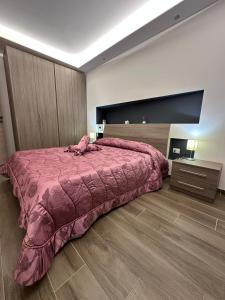 a bedroom with a large bed with a pink comforter at Alloggio Nola - casa e box auto in Nola