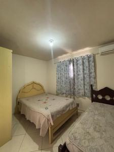 Un dormitorio con una cama y una ventana con cortinas. en Recanto dos Monteiros, en Vila Velha 5 fotos más