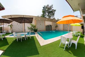 a patio with tables and umbrellas and a pool at Las Cascadas Resort in Naranjillo