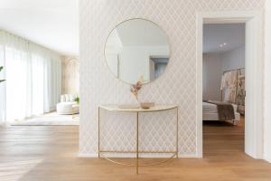 a living room with a round mirror and a table at NUOVO Luminoso 36 Giardino - Treviso Venice in Treviso