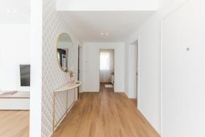 a hallway with white walls and a mirror at NUOVO Luminoso 36 Giardino - Treviso Venice in Treviso