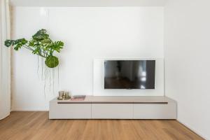 a living room with a tv on a white wall at NUOVO Luminoso 36 Giardino - Treviso Venice in Treviso