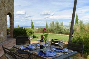 a table with a bottle of wine and glasses at Relax Palazzo Monaci in Asciano