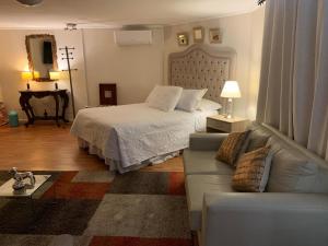 a living room with a bed and a couch at Habitación Deluxe Acogedora Elsita in Santiago