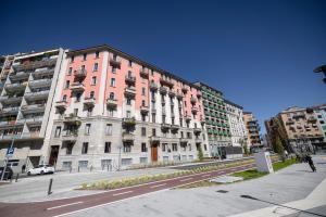 un gran edificio rosa en una calle de la ciudad con edificios en Moderno Trilocale in Zona Navigli, en Milán