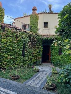 an ivy covered building with a building with a door at Villa a Rocchetta Luxury Guesthouse in Monterosso al Mare