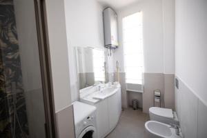 Un baño blanco con lavabo e inodoro. en Moderno Trilocale in Zona Navigli, en Milán 17 fotos más