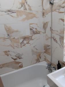 Un baño con bañera blanca y lavabo. en 3BR Sleeps 10 Walk to Alex Park, en Mánchester 81 fotos más
