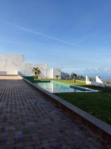 a swimming pool in front of a building at Villa Beni Mejmel avec vue exceptionnelle in Tangier
