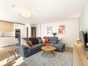 a living room with a blue couch and a table at The Town Place Clifden Boutique Apartments in Clifden