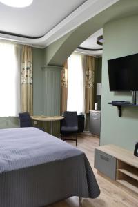 a bedroom with a bed and a table with chairs at Tornácos Vendégház Kőröshegy in Kőröshegy