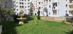 a yard with a fountain in the middle of a building at Superbe appartement emplacement exceptionnel in Tunis
