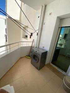 a washing machine in a room with a balcony at Superbe appartement emplacement exceptionnel in Tunis