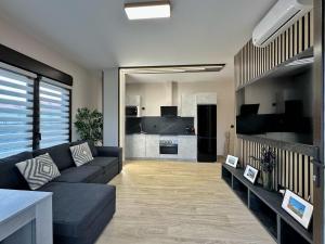 a living room with a couch and a kitchen at Flower Deluxe Bajo con Jardin 6083 in Noja