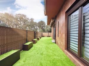a courtyard with green grass on the side of a building at Flower Deluxe Bajo con Jardin 6083 in Noja