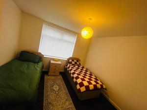 a bedroom with two twin beds and a window at Liberty Guest House in Liverpool