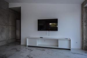 a white room with a tv on a wall at Sweetstaybykw Moderna Casa Campo con Piscina in Asprillas