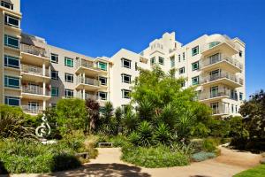 a large apartment building with plants in front of it at Bright Light Filled 1 Bedroom Apartment in Melbourne