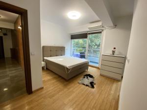 a bedroom with a bed and a dog laying on the floor at Apartment Elena in Skopje