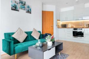 a living room with a green couch and a coffee table at Grand Central , 2 double bedroom apartment with free parking , Birmingham in Birmingham