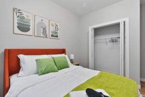 a bedroom with a bed with green and white pillows at Comfy Rm, 1 Bed Near Downtwn Indy in Indianapolis