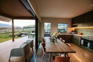 a kitchen and dining room with a wooden table and chairs at Rangers Retreat - Mountain Views - Rural in Lake Hawea