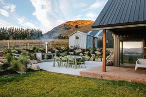 a patio with a table and chairs and a house at Rangers Retreat - Mountain Views - Rural in Lake Hawea +11 photos